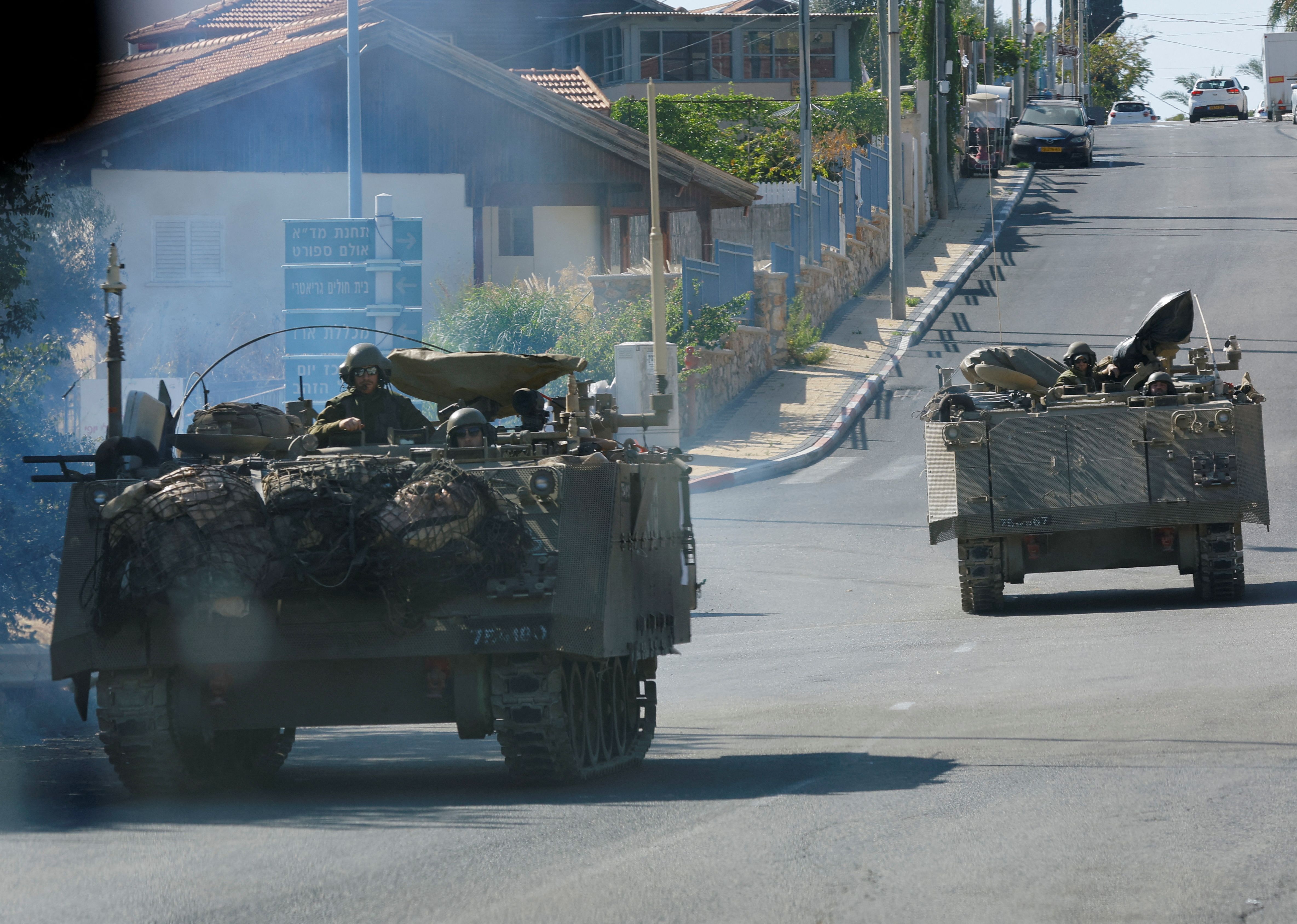 Israeli military vehicles ride in northern town of Shlomi near the border with Lebanon, November 7, 2023.  