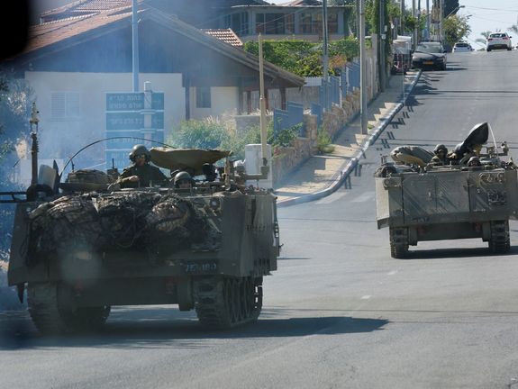 Israeli military vehicles ride in northern town of Shlomi near the border with Lebanon, November 7, 2023.