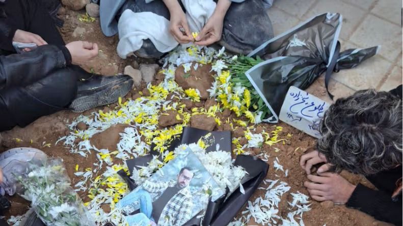 Flowers placed on grave during a memorial for Arash Tolou Shekhzadeh.