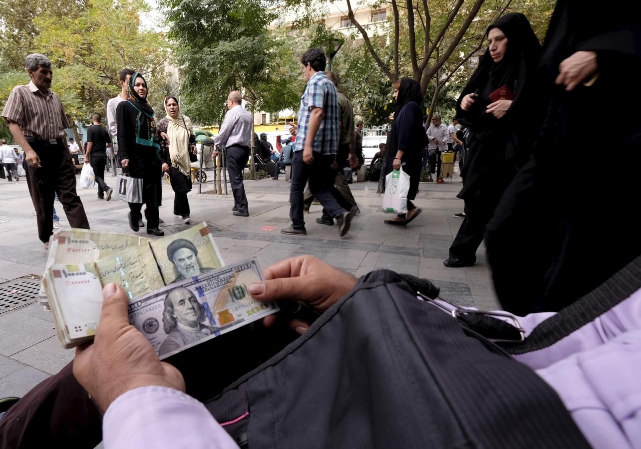 A money changer displays US and Iranian banknotes at the Grand Bazaar in central Tehran October 7, 2015.