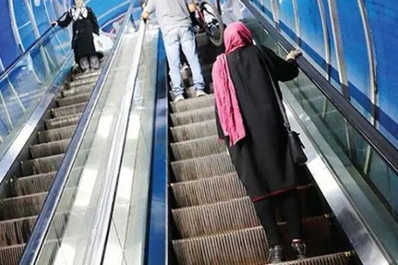 Commuters ride escalators inside a metro station in Tehran.