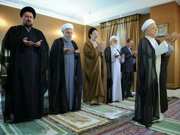 Former president Rafsanjani leading a prayer with Mohammad Khatami (C) and Khomeini's grandson (L) as well as former president Hassan Rouhani (2nd left) standing behind him (file photo)