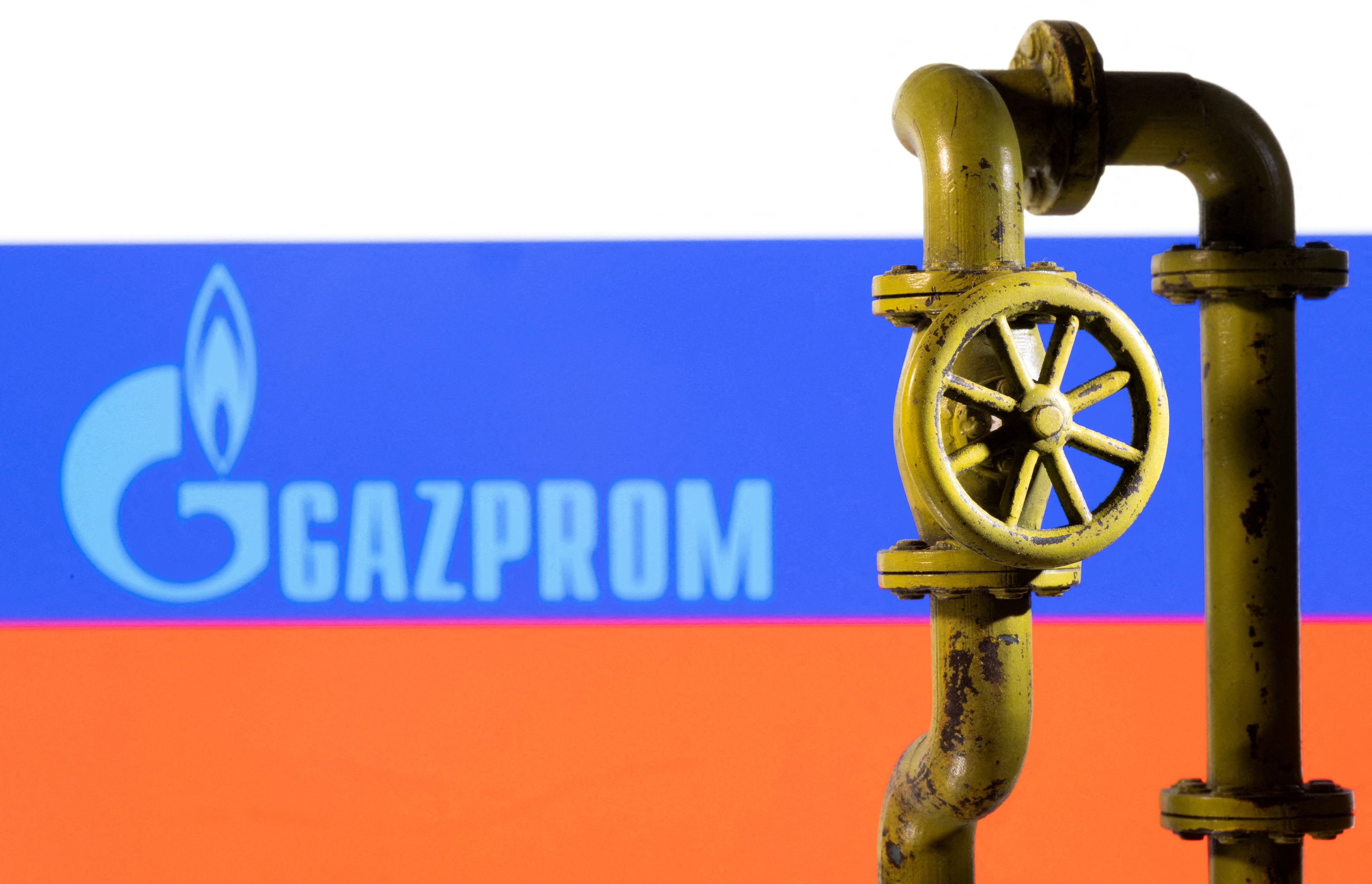 A 3D printed natural gas pipeline is placed in front of displayed Gazprom logo and Russian flag in this illustration taken February 8, 2022.