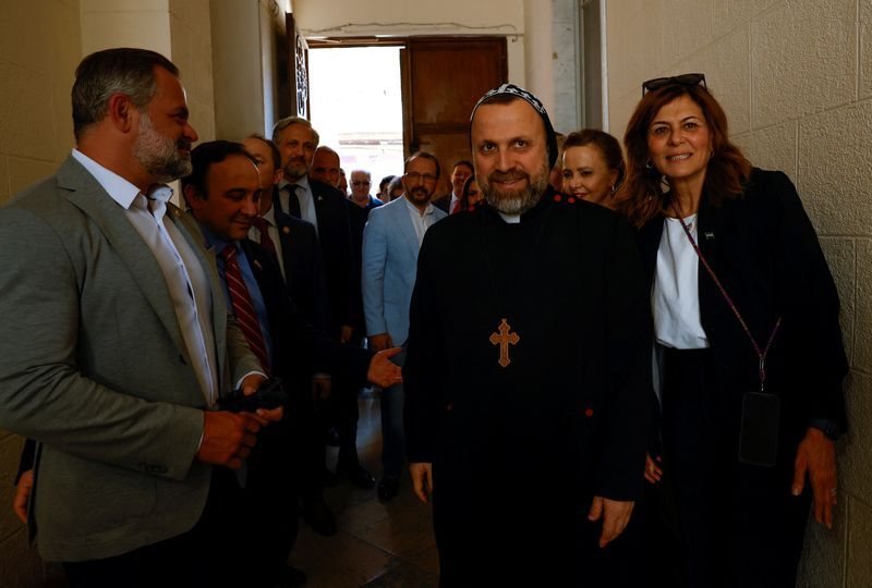 کوری میلز، سمت چپ تصویر، در جریان سفر خود به سوریه با اسقف کلیسای ارتدوکس این کشور دیدار کرد. ۱۸ آوریل ۲۰۲۵ 