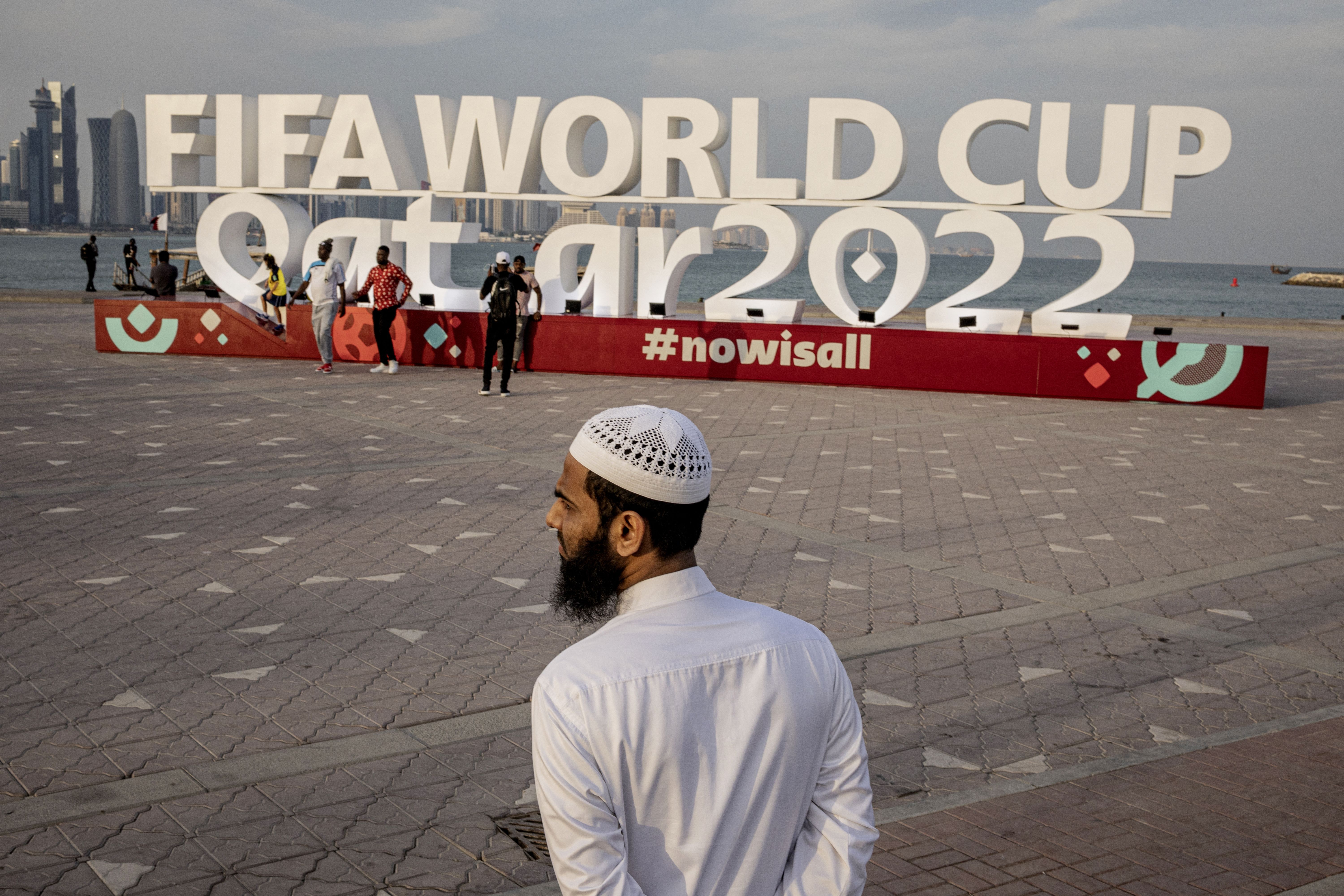  A man is pictured in front of a FIFA World Cup Qatar 2022 sign in Doha, November 17, 2022. 